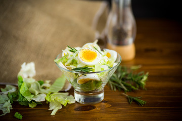 fresh spring salad with cabbage, lettuce and boiled eggs with rosemary and spices