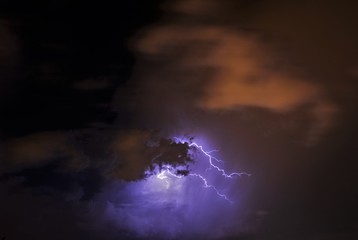 lightning between the clouds at night