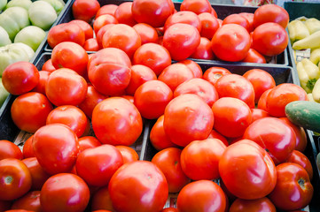 Pile of red, green tomatoes and jalapeno in plastic wood crate at farmer market in Washington, USA