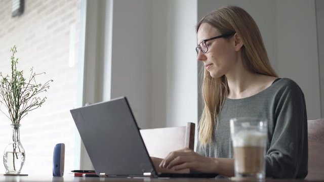 Frau im Homeoffice am Laptop in der Wohnung