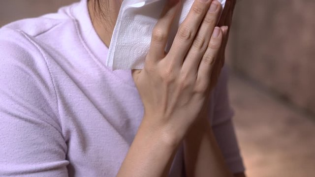 4k Asian woman coughing, young adult female wear pink tshirt, sit on couch, cough on hand paper towel, covid19 corona virus, health crisis, short hair asian model, rapid lung cancer, call 911 for help