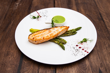 Grilled salmon steak, asparagus and broccoli sauce on a plate.