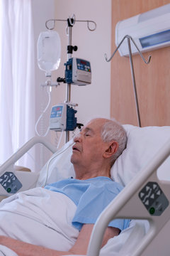 Old man, 90 years old, in a hospital bed, very ill