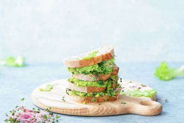 Avocado and green sprouts salad sandwiches, healthy eating concept, front view