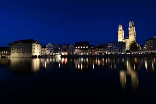 the old town of zurich switzerland on the limmat river at night with the grossm&uuml;nster