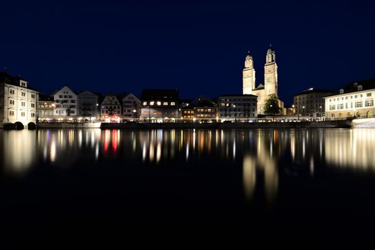 the old town of zurich switzerland on the limmat river at night with the grossm&uuml;nster