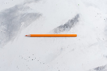  Orange pencil on a white stone table