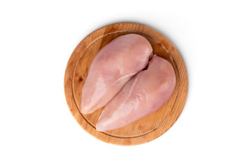 Raw chicken fillets on wooden board isolated on white background.