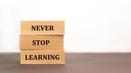 Never stop learning word written on wood block on white background. Time to say text on wooden table for your desing, concept.