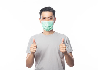 Young Asian Man wearing hygienic mask and showing thumbs up to prevent infection, 2019-nCoV or coronavirus. Airborne respiratory illness such as pm 2.5 fighting and flu isolated on white background.