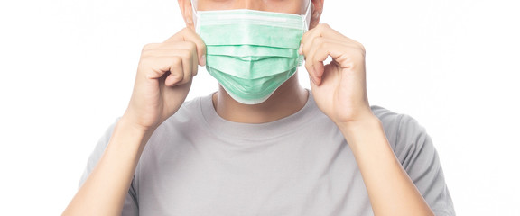 Closeup Young Man wearing hygienic mask to prevent infection, 2019-nCoV or coronavirus. Airborne respiratory illness such as pm 2.5 fighting and flu isolated on white background. Banner size.
