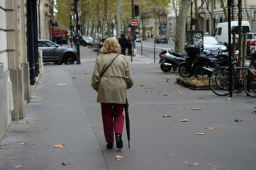 Vieille femme marchant en s'appuyant sur son parapluie, Paris