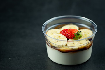 Bowl of fresh milk pudding, sliced banana and strawberry with sauce chocolate