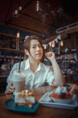 Young female student eating cake in a coffee shop