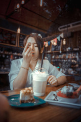 Young female student eating cake in a coffee shop