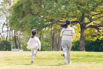 春の公園で遊んでいる可愛い子供姉妹