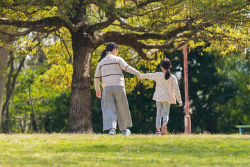 春の公園で散歩している子供姉妹