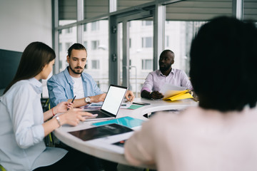 Multiracial staff of company sharing ideas at briefing office at daytime