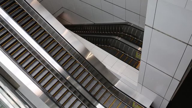Close-up shot of empty moving staircase running up and down. Modern escalator stairs, which moves indoor.