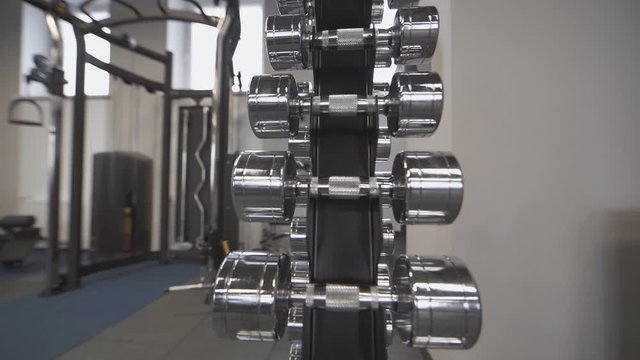 Dumbbell set. Close up many metal dumbbells on rack in the gym or fitness center