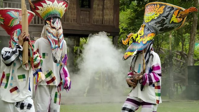 The  people in Thailand on phitakhon ghost festival holiday carnival wearing colorful custume clothes wearing hand paint mask dancing on street with happiness.  