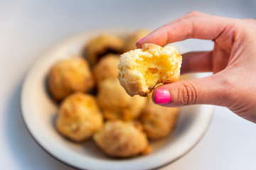 "Chipa"  tipica comida de Paraguay y el norte de Argentina. Es parecido a un pan de queso. Mano de mujer sostiene una unidad y el resto est&aacute;n sobre un plato.