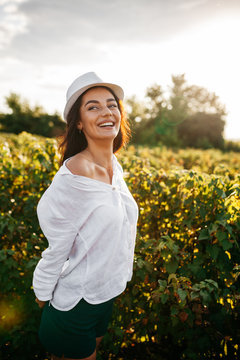 beautiful sweet sexy girl in a white dress walking on a field of sunflowers , smiling a beautiful smile,cheerful girl,style, lifestyle , ideal for advertising and photo sun shines bright and juicy
