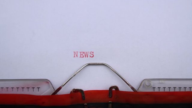 News - word printed on an old typewriter in red letters, close up. vintage inscription