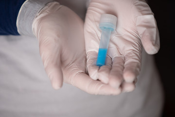 nurse in white surgical gloves holds test tube with coronavirus vaccine to stop the pandemic that has been spreading around the world since February 2020