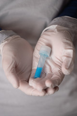 nurse in white surgical gloves holds test tube with coronavirus vaccine to stop the pandemic that has been spreading around the world since February 2020
