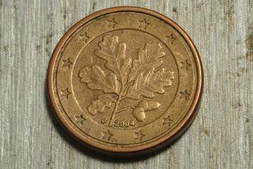 A closeup of an isolated coin on a wooden blackboard.