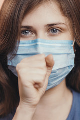 sick woman in medical mask coughing on studio background, concept of prevention viral deseases, person with breathing problems