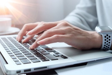 Fototapeta premium Asian woman is typing on keyboard of laptop or computer notebook for check electronic mail, preparation of presentation in meeting, get information for shopping online or operation of internet banking
