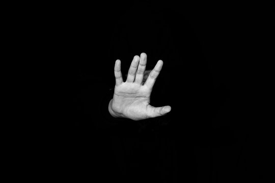 man's hand out of the dark. black and white