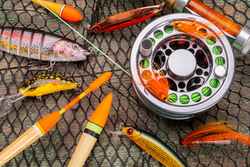 different fishing tackle on wooden background