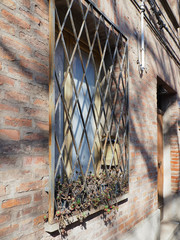 Window with railing. The mailbox is inside the railing. There are succulents on the windowsill.