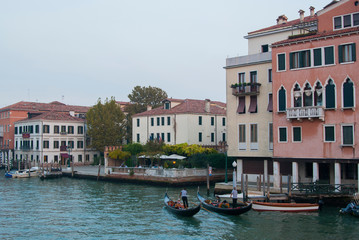 Fototapeta premium Twilight in Venice, Italy. View of the Grand Canal and houses on the shore, people ride boats.