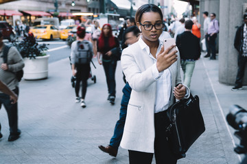 Naklejka premium African American lady making video call in city