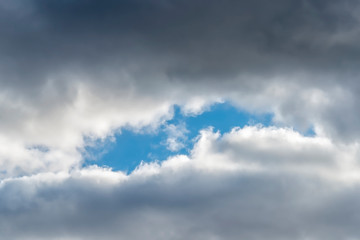 Window of the clear blue sky among the clouds. Natural frame for creativity.