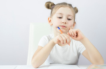 little girl of primary school at the table teaches lessons, the concept of education