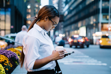 African American lady browsing social media on street