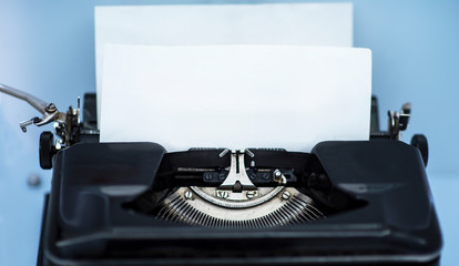 Old vintage typewriter with a blank sheet of paper inserted
