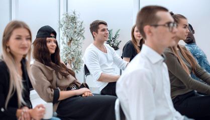 diverse young people applauding while sitting in the same row