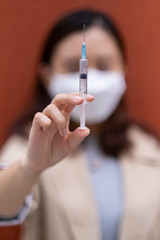A Chinese woman holds an injection needle.