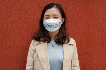 A Chinese woman wearing a face mask rejects to be touched due to COVID-19.
