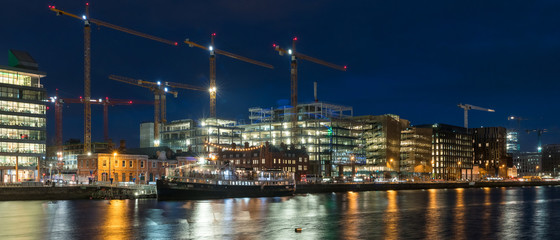 Beautiful night view scene Dublin city center old town Ireland cityscape reflection river Liffey long exposure Samuel Beckett Bridge