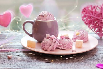 Cup of coffee with meringues and marshmallows, Turkish delight on a plate, hearts, illumination, against the background of a window, homeliness, romantic greeting, happy birthday