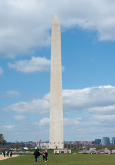 Tourists walk towards the towering Washington Monument 