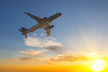 Fototapeta na wymiar airplane silhouette fly across a sky at the sunset