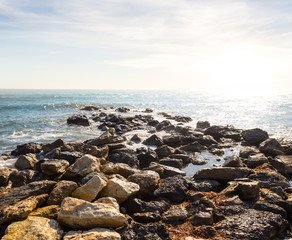 Fototapeta na wymiar stormy sea coast with stones at the early morning, marine cape scene